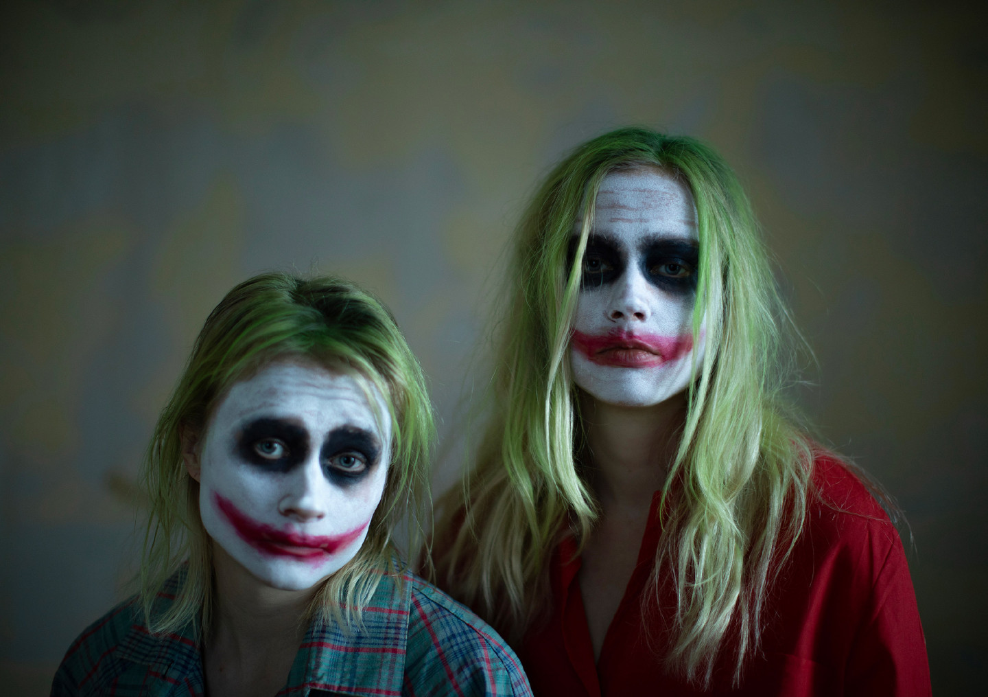 Maustetytöt lähikuvassa, katseet kameraan, kasvoilla klovnimaalaukset